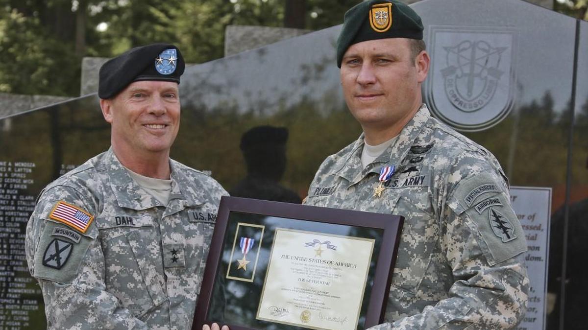 Then-Sgt. 1st Class Earl D. Plumlee, right, assigned to 1st Special Forces Group at JBLM, is presented the Silver Star Medal for his actions in Afghanistan at Joint Base Lewis-McChord in 2015. He now is set to receive the Medal of Honor from President Joe Biden.