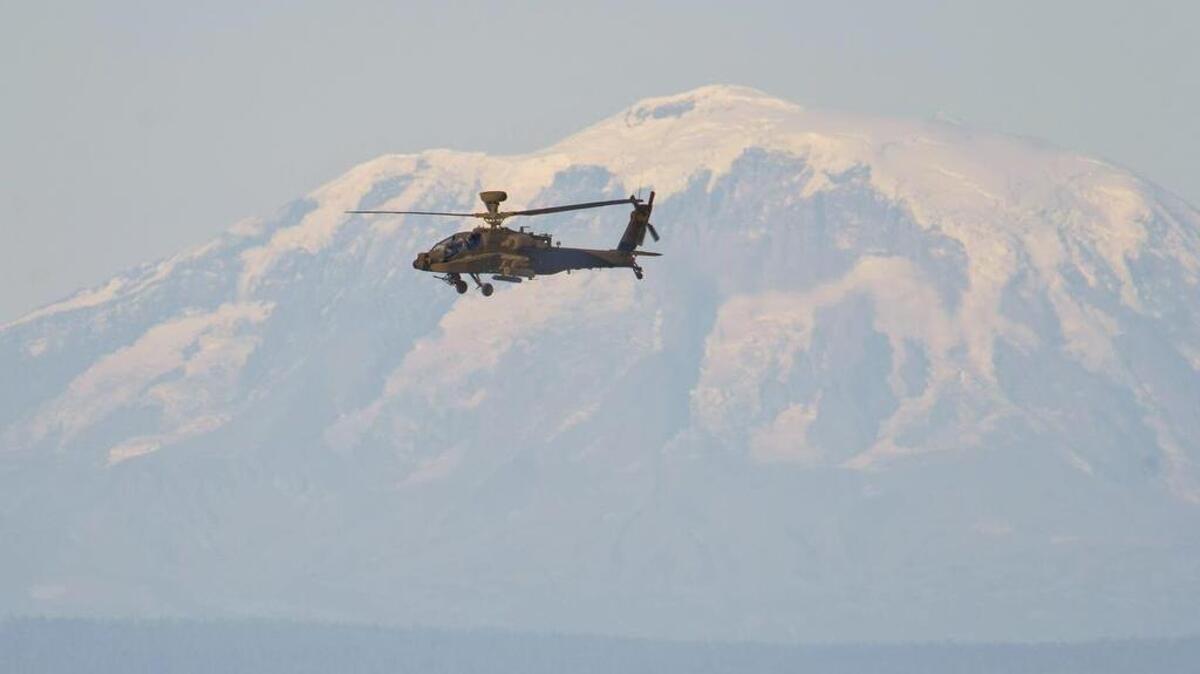 
FILE PHOTO: An Apache attack helicopter files over the Yakima Training Center during an air-to-ground missile exercise at the Yakima Training Center, September 10, 2013. Mt. Adams is in the background. It was part of Joint Base Lewis McChord's 20th annual Operation Rising Thunder in which the 7th Infantry Division welcomed soldiers from the Japanese Ground Self-Defense Force for joint training exercises at the Yakima Training Center for several weeks.
