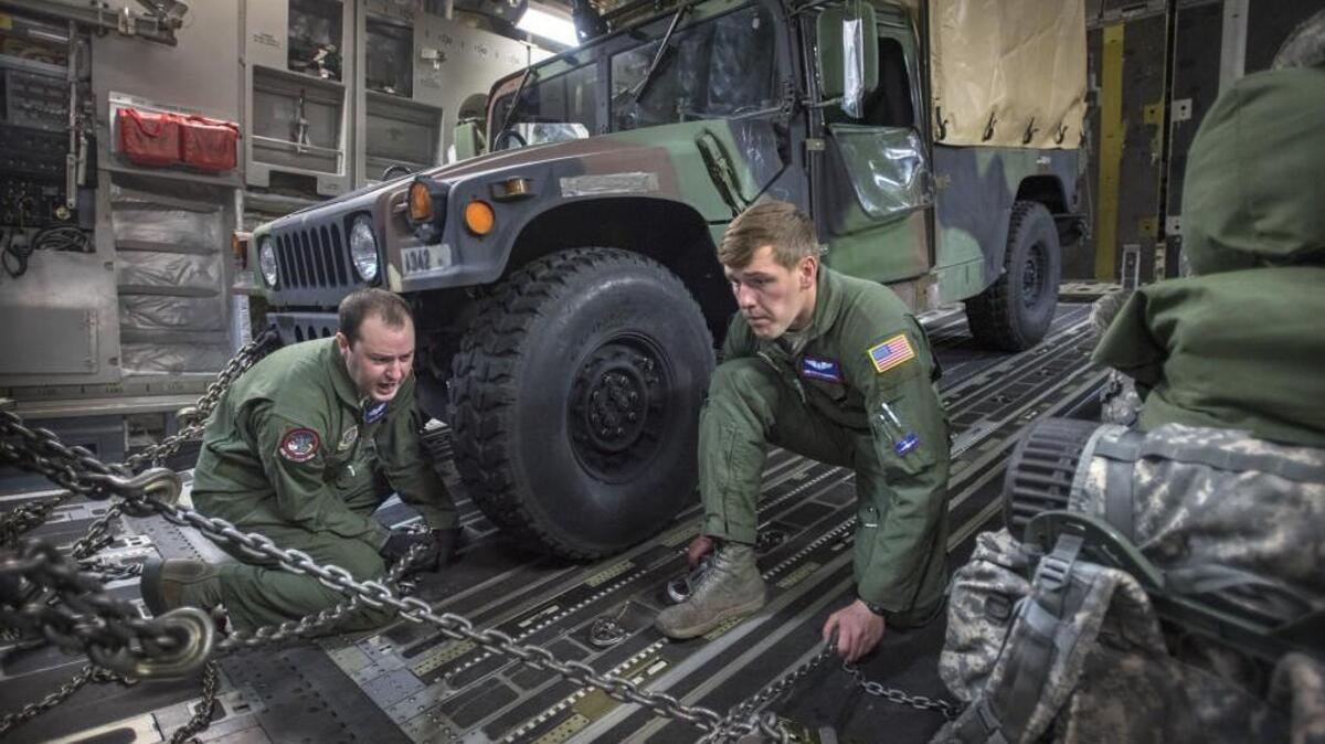 Staff Sgt. Jon Fabis, left, and Airman Austin Campbell secure I Corps vehicles and equipment inside an Air Force C-17 transport as they prepare Wednesday for a flight to Naval Air Station Whidbey Island during a rehearsal exercise for rapid deployment of the early entry command post from McChord Field at Joint Base Lewis-McChord.