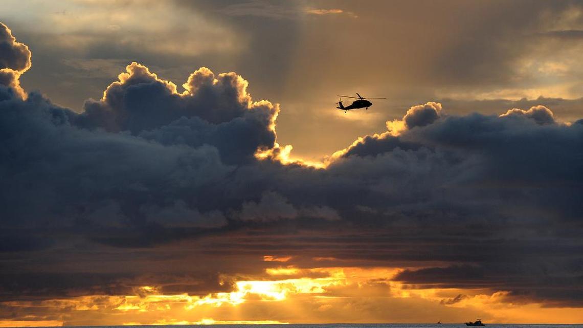 A military helicopter flies over the waters of Agana Bay in Hagatna, Guam, on Aug. 10. Residents can expect to see more military aircraft in the skies above the U.S. territory as base realignment in the Pacific shifts more Marines to Guam from Okinawa.