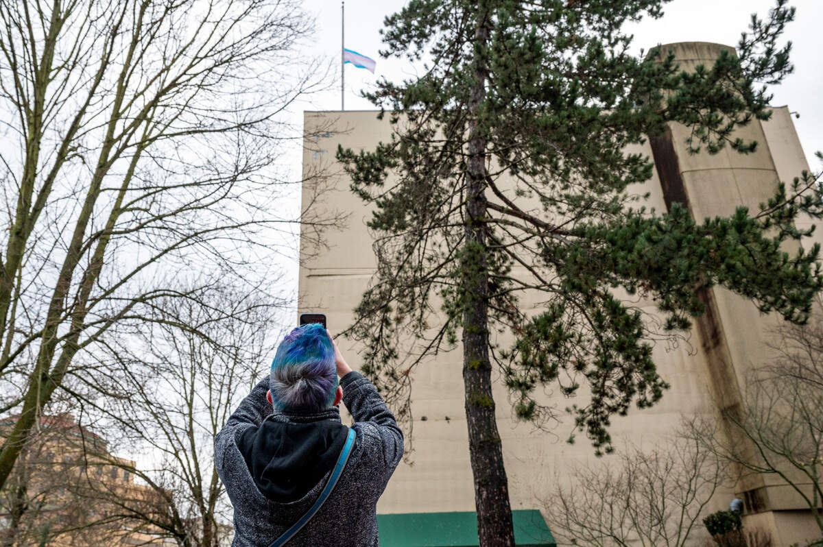 Kendal Holzman of Tacoma photographs the Transgender Pride Flag that was raised at Tacoma City Hall on Friday morning. Once the flag was raised, it was then dropped to half staff in preparation for Nov. 20, the annual Transgender Day of Remembrance which honors those lost to hate crimes due to their gender identity. The raising of the flag was part of a ceremony on Friday that accompanied the city’s first Transgender Day of Remembrance Proclamation earlier this week.