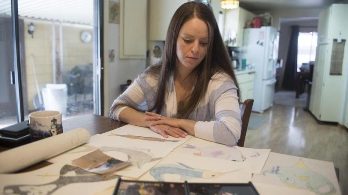 Tami Cleveland looks at sketches made by her stepmother, Beth Cleveland, at her home in Rosalia on Sunday, Mar. 12, 2017. Beth Cleveland, a hospice nurse, died of a painkiller overdose in 2012. The veteran nurse had sought the painkillers for debilitating headaches, but inadvertently overdosed.