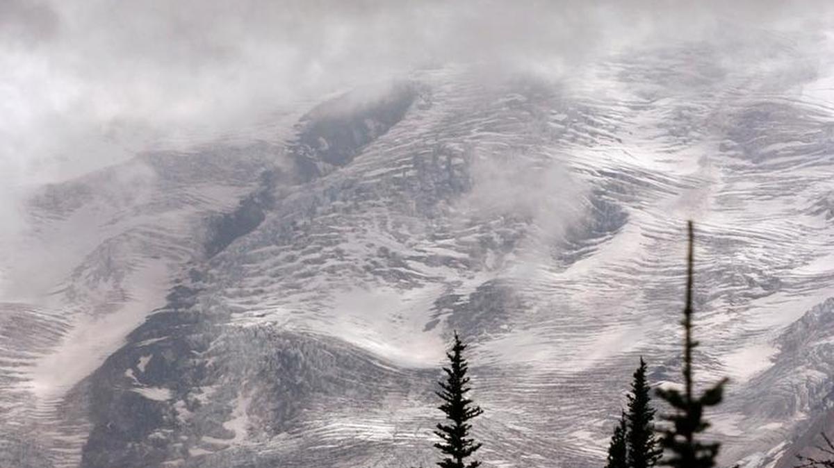 Emmons Glacier reflects a bit of sunlight as a cloud envelopes the summit of Mount Rainier in 2003. Sunday a skier descending Emmons Glacier died after falling into a 150-foot crevasse.