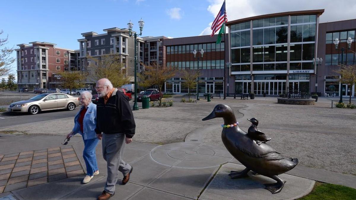 Helen McDanial, 74, and Don McDaniel, 77, walk through University Place's Town Center in 2014. The easy access of their unit in the new Clearview 100 Apartments to shopping, medical needs and a main bus line convinced the couple to downsize here from their former two-story home in Astoria, Ore.