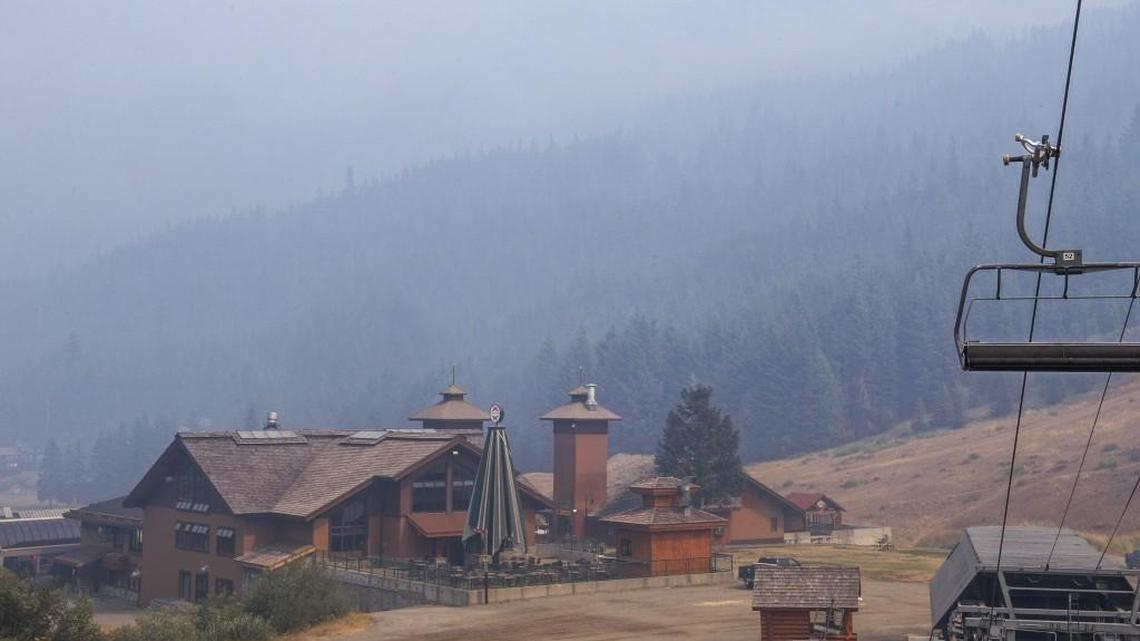 Smoke nearly obscures a hillside near Crystal Mountain Ski Resort on Wednesday. The day before, the Norse Peak wildfire burned rapidly down that slope, threatening the resort.