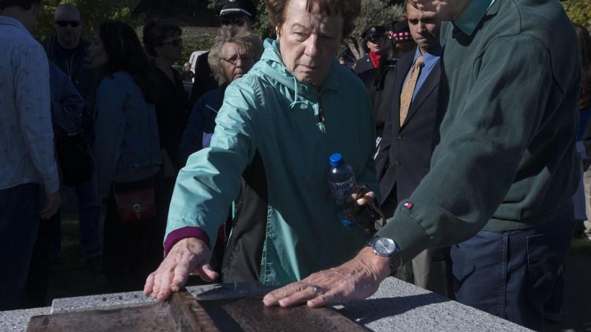 Joan Miller and her husband, Robert, touch a piece of steel from the New York City’s World Trade Center at the Tacoma Firefighters Memorial during 2014’s ceremony marking the Sept. 11, 2001, attacks.