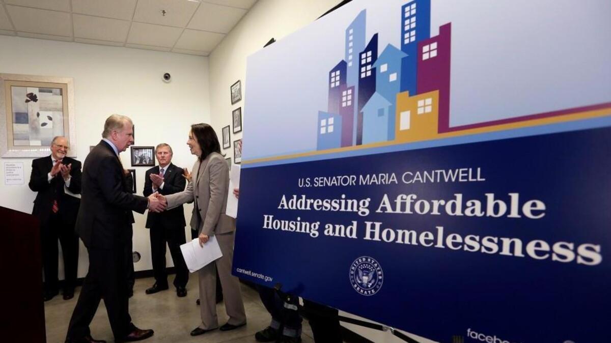 Seattle Mayor Ed Murray, left, shakes hands with Sen. Maria Cantwell as they take turns speaking at an affordable housing complex, Thursday, March 24, 2016, in Seattle. Cantwell met Tuesday with officials in Tacoma.