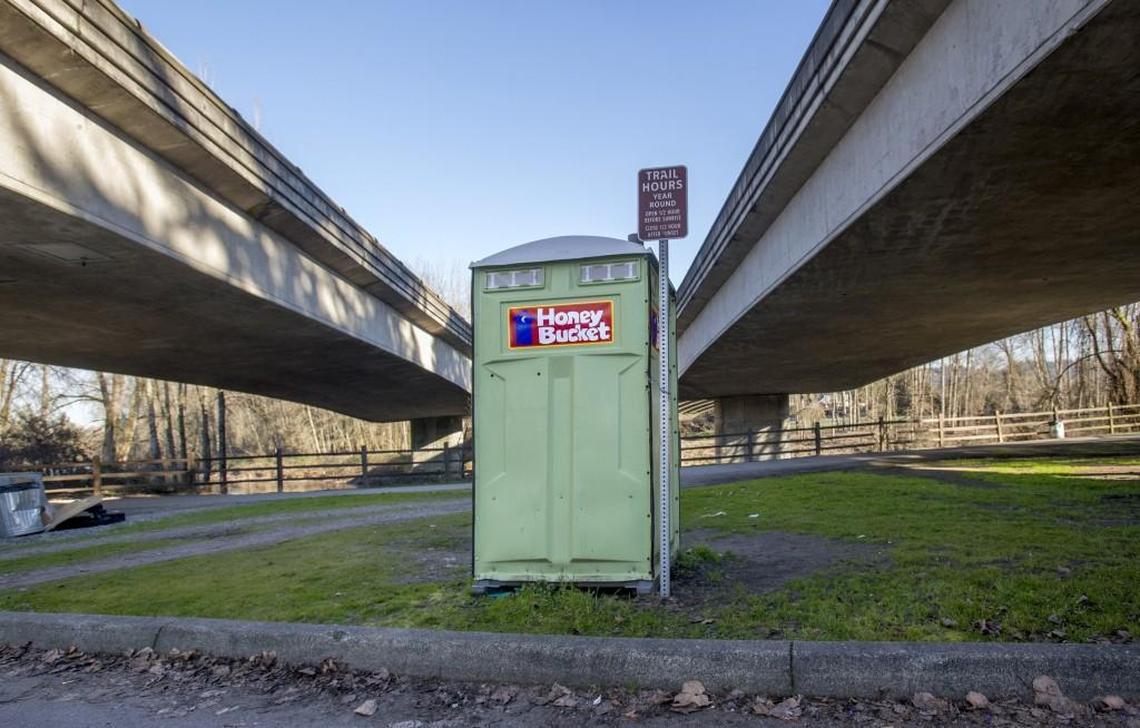 A portable toilet sits near a parking lot near the Foothills Trail along the Puyallup River under state Route 512 in Puyallup, February 13, 2018. The Puyallup City Council voted recently to remove other portable toilets meant to serve people experiencing homelessness.
