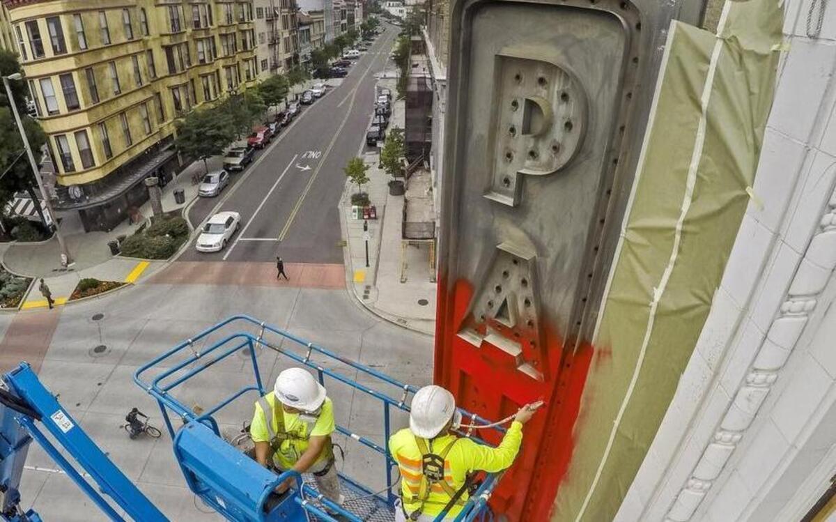 Painters Nolberto Baca (left) and Jefferson Oliva work on the Pantages Theater sign, part of a 2016 exterior renovation of the structure in downtown Tacoma.