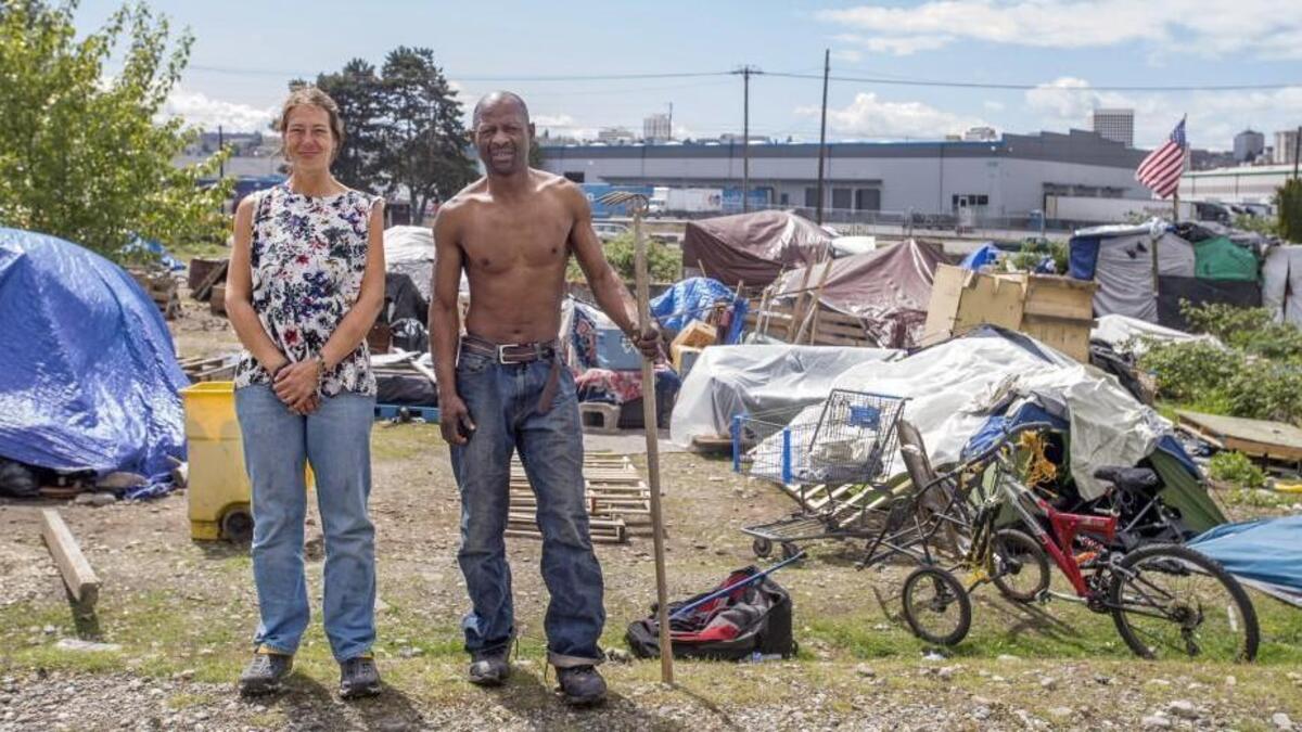 Angel Fox and Johnie "Demon of Love" Robinson create an updated "American Gothic" at the large encampment of homeless people near East 18th Street and Portland Avenue.