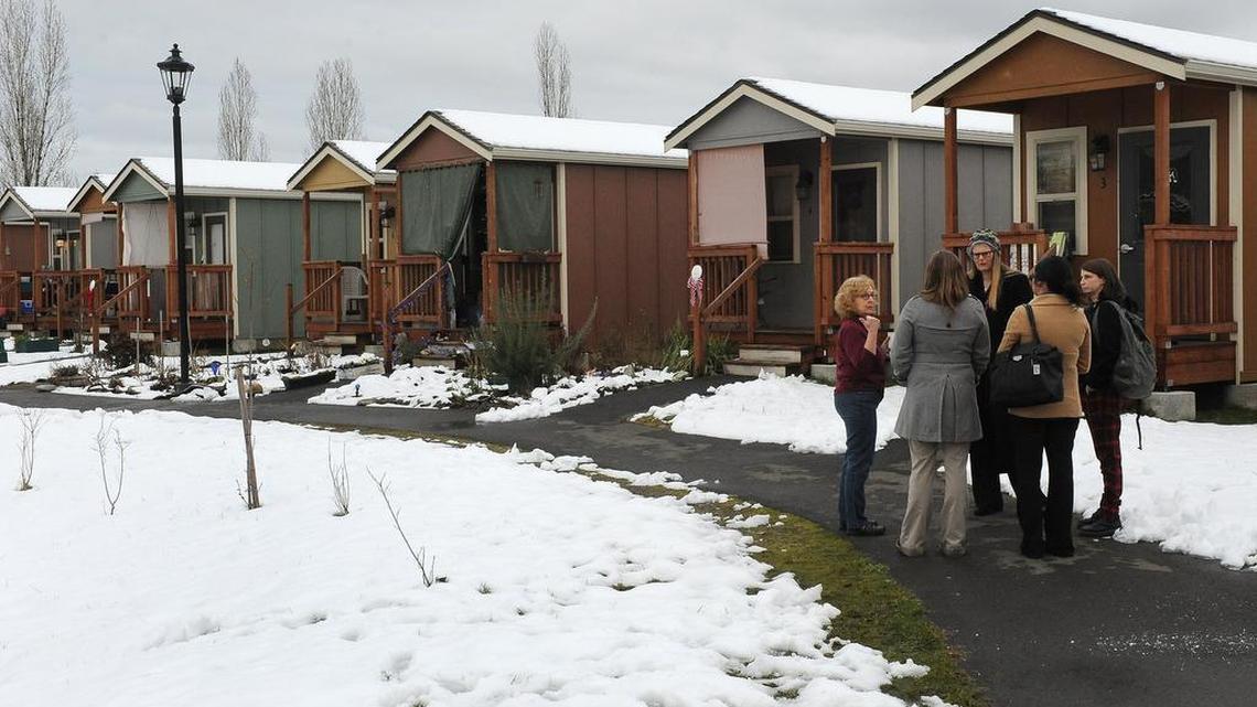 Panza board member Jill Severn, left, answers questions during a cottage tour as Quixote Village celebrated its 10th anniversary Feb. 7. Once a transitory tent camp for homeless adults, the village has grown into a community of 30 small cabins, a community building and a garden. It is overseen by the nonprofit organization Panza.