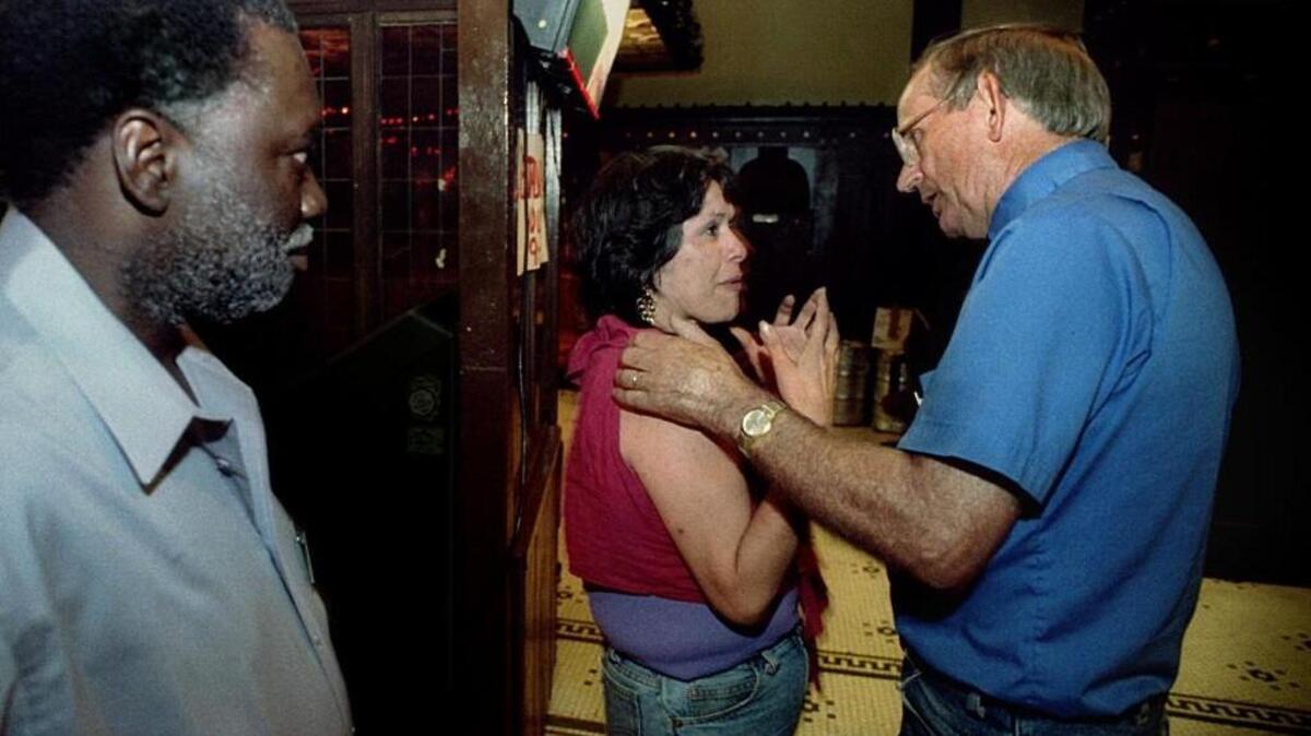 The Rev. Dean Jones, right, talks with Karen Satiacum, center, during a 1994 visit to the Olympus Hotel Bar in Downtown Tacoma.