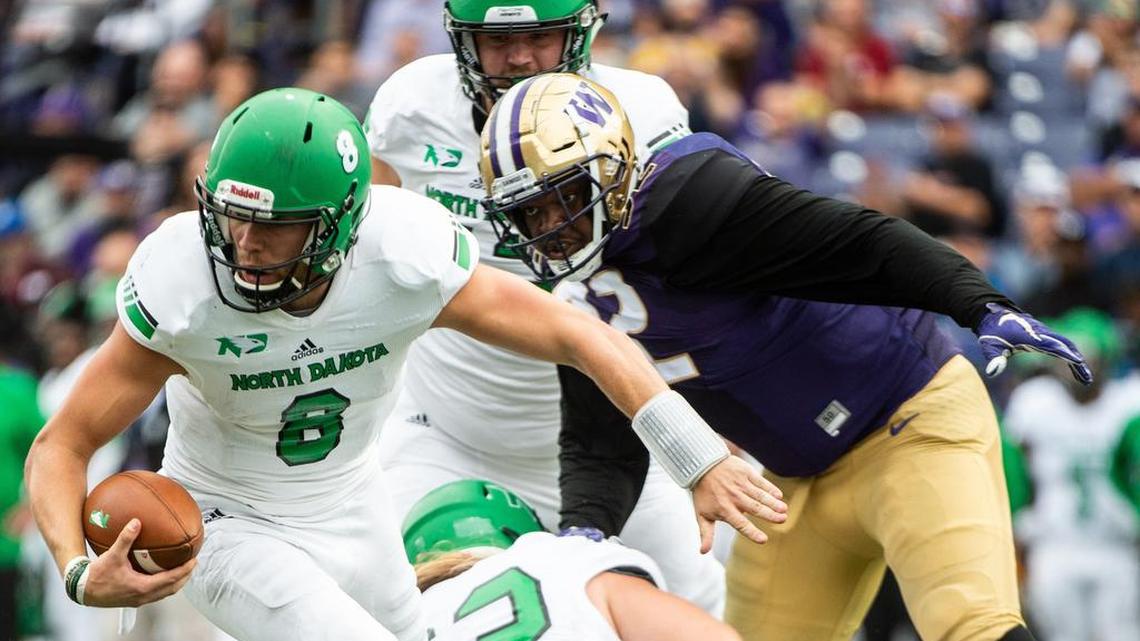 North Dakota quarterback Nate Ketteringham (8) escapes pressure from Washington defensive lineman Jaylen Johnson in the second quarter. The University of Washington played North Dakota in a NCAA football game at Husky Stadium in Seattle, Wash., on Saturday, Sept. 8, 2018.