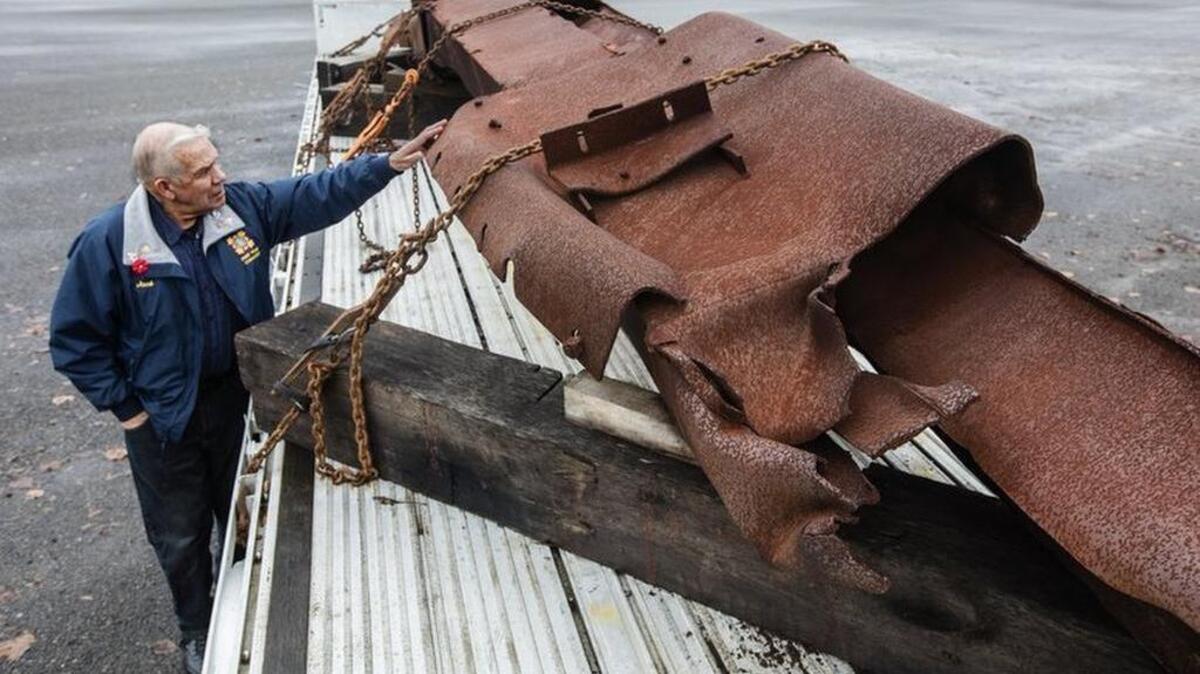 Jack Chandler touches the 36-foot piece of the World Trade Center that was part of the 90th or 91st floor before it came crashing down on 9/11. His dream is to create a memorial in Milton by standing the piece on its end in a community park. While awaiting a decision by the city of Milton, the piece is resting on a flatbed truck in a Fife storage yard.
