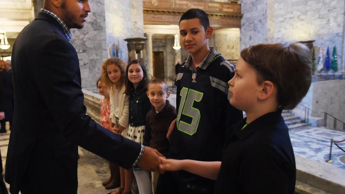 Seattle Seahawks wide receiver Jermaine Kearse greets 10 year-old Brendan Kane from Allyn as Brian Trujillo,13, from Bremerton and other young admirers look on before Kearse headlined a reception Monday at the State Capitol honoring Gold Star children and their families.