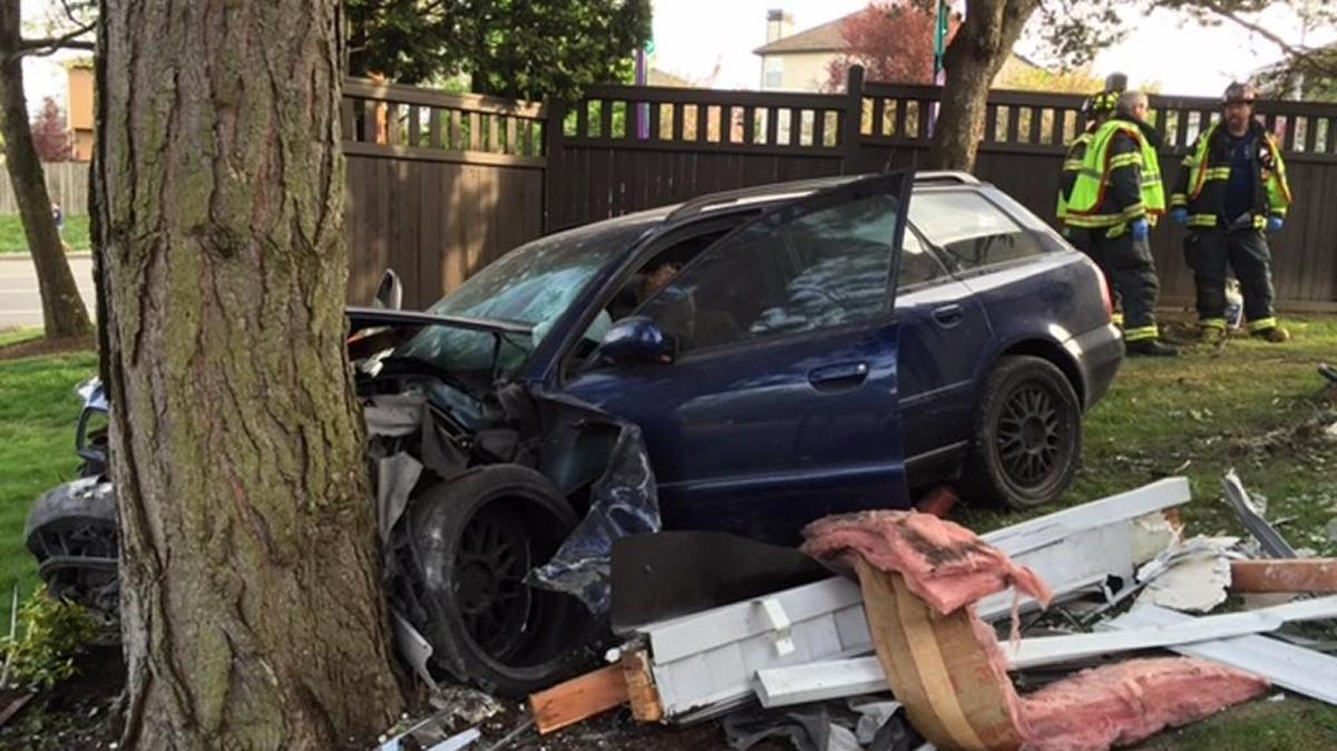 Insulation and a post from a Kent apartment lie around a car that went through the building before hitting a tree Wednesday.
