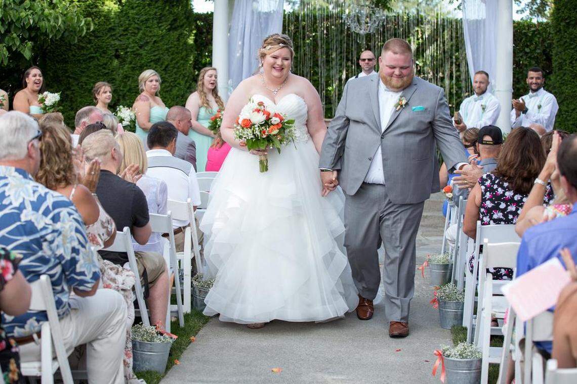Ashlynne and Paul Glassman walk down the aisle, moments after being marrie ind July 2018 at the Orting Manor. 