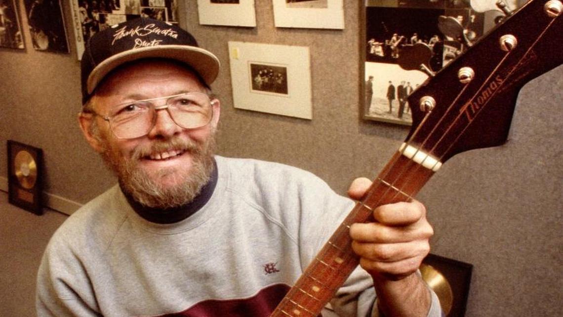Ex-Wailer Buck Ormsby, yielding a classic Thomas guitar he played in the band’s heyday, stands before several prints of an exhibit of equally classic like-era rock ’n’ roll photographs on display at the Tacoma Public Library in 1993.