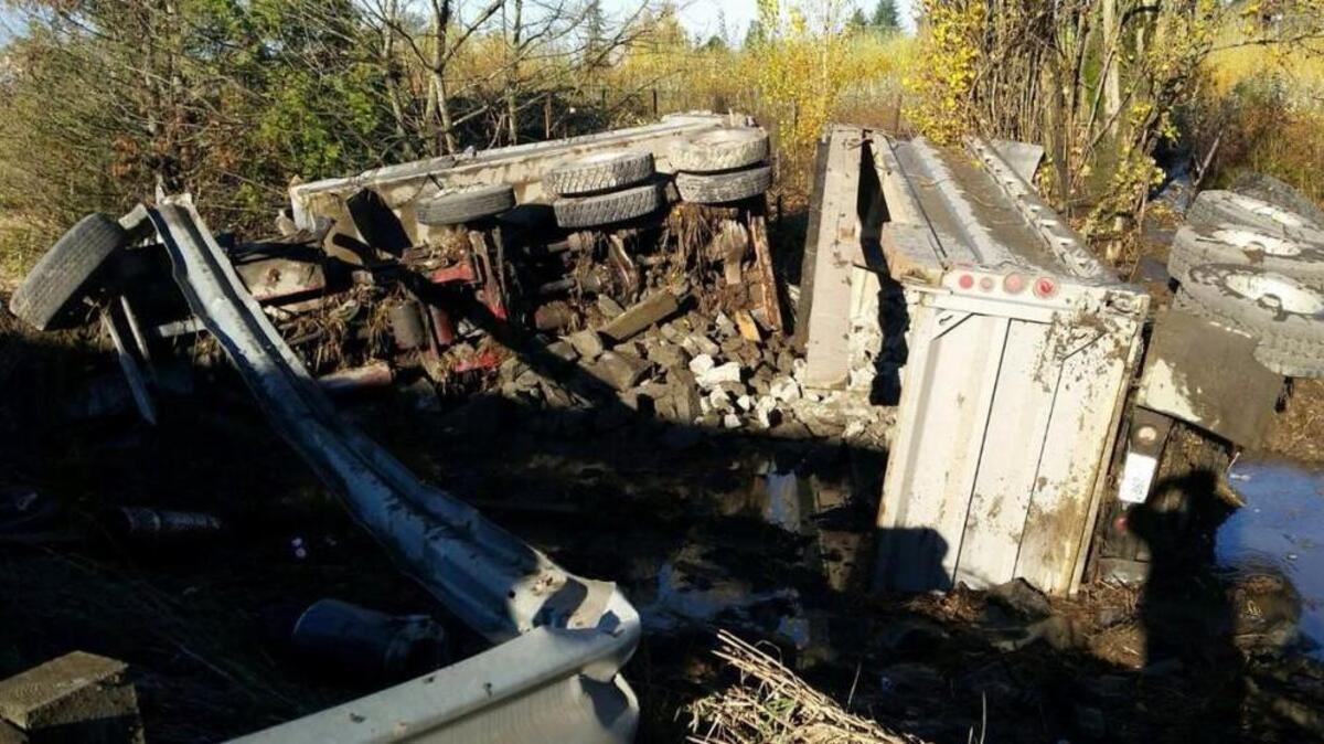 A dump truck rests alongside southbound Interstate 5 in Fife on Tuesday afternoon. The truck blew a tire before going off the side of the freeway, according to the Washington State Patrol. The driver suffered only minor injuries.