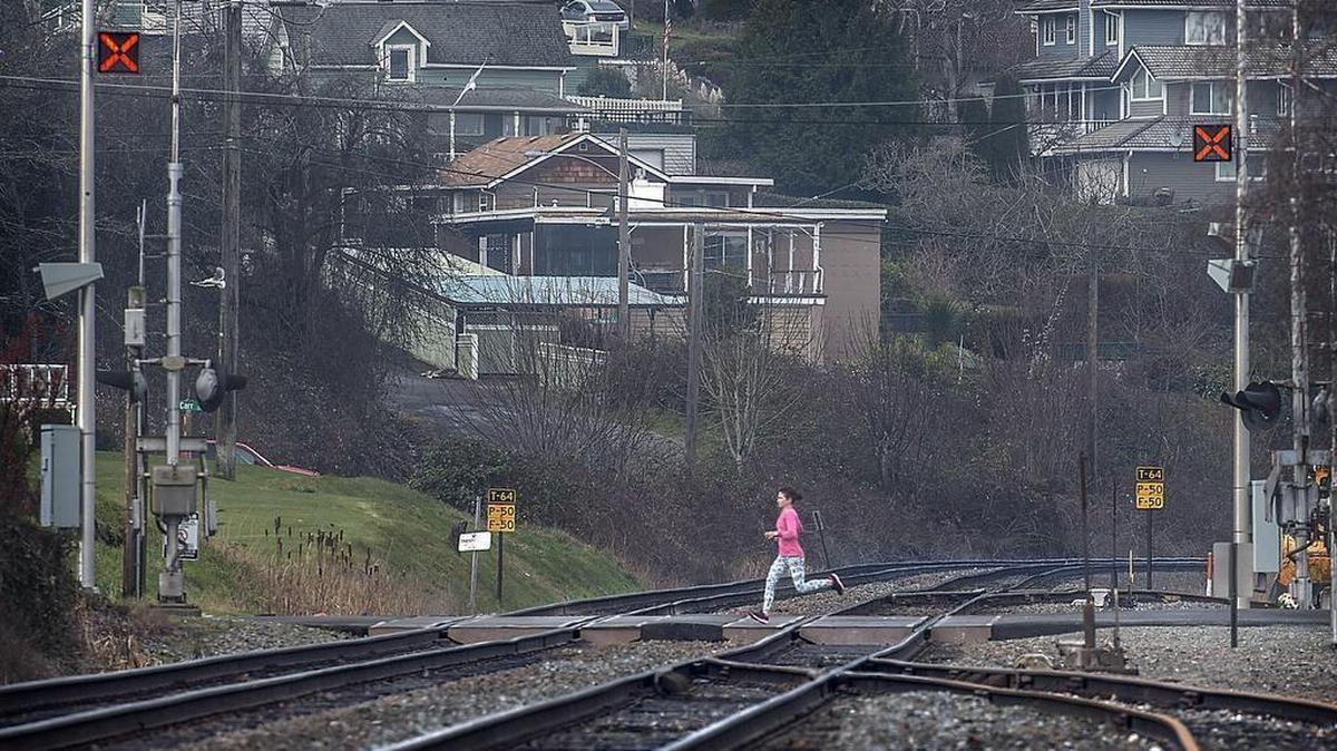A lone runner in January jogs over the rail crossing at North McCarver St. and Ruston Way, which has been the scene of two fatal train pedestrian collisions in the past two years. Lawyer Phil deMaine is helping mobilize friends and family members of the victims in a campaign to force the city of Tacoma and BNSF to make safety upgrades at the crossing.