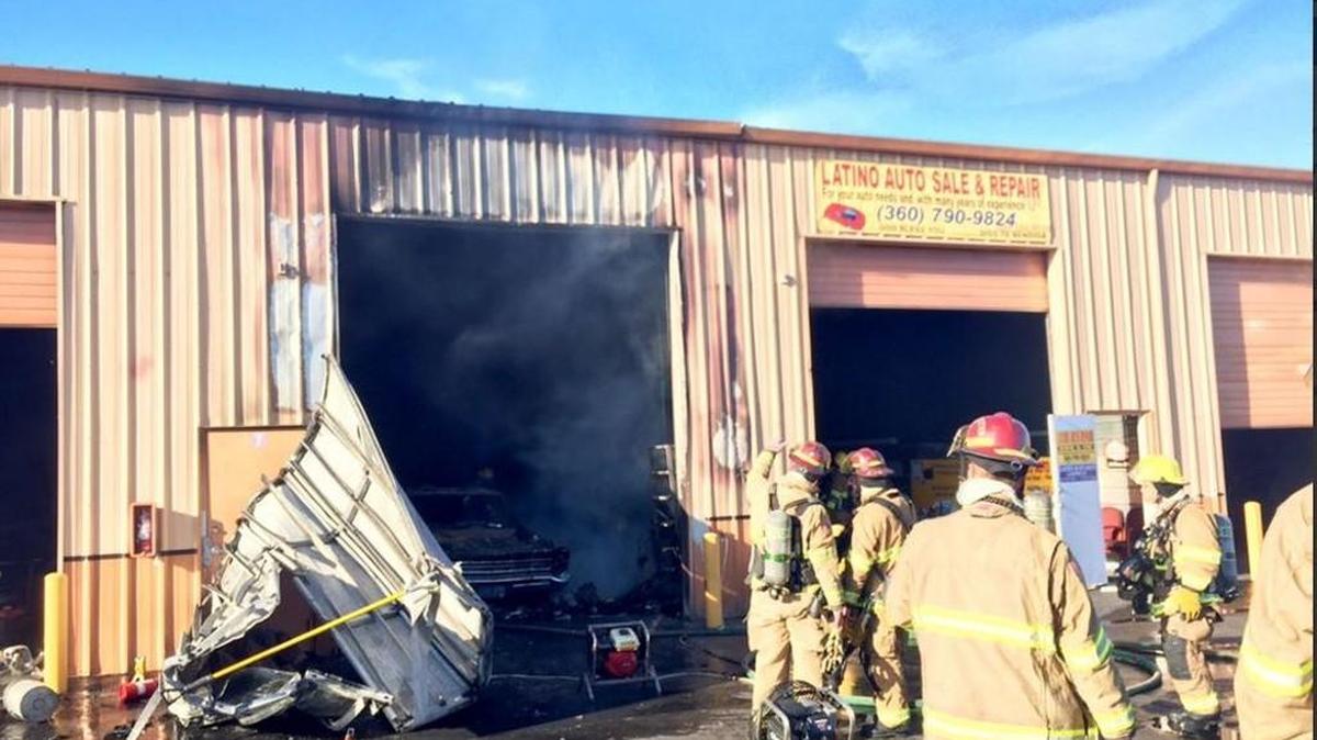 Firefighters douse flames at an autobody shop near South 74th Street and South Tacoma Way on Wednesday morning.