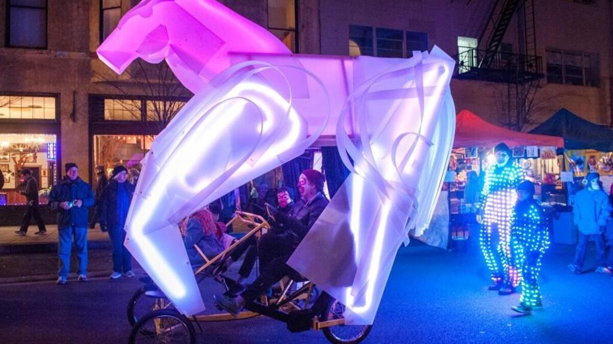 Wearing illuminated suits comprised of over 400 battery-powered lights, Dale Hillius and his daughter, Isabelle, walk behind an illuminated horse in the World's Shortest Parade at Tacoma's First Night celebration on Dec. 31, 2015.