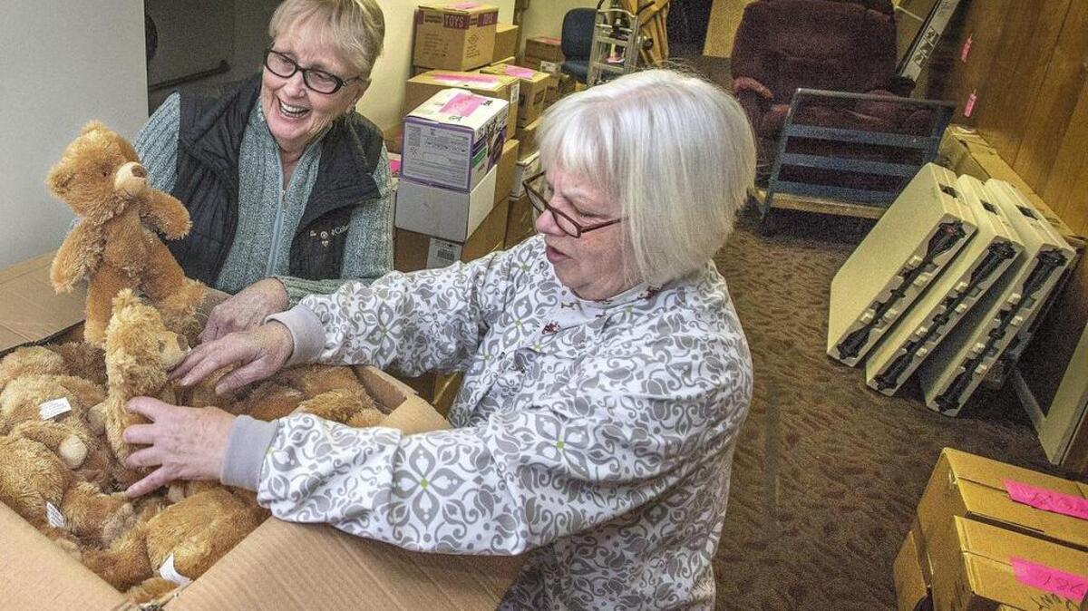 Alyce Brame-Galyean, right , of the nonprofit Springbrook Connections, was overjoyed Monday to receive a box full of plush teddy bears along with other donated Christmas basket items from Caring for Kids Director Diane Formoso. Brame-Galyean and board member James Yastrum (not pictured) packed their car full of gifts for the second annual Springbrook Christmas Giveaway to be held on Saturday from 11 a.m.-1 p.m. at Centerforce in Lakewood. The giveaway will provide gifts and decorations for needy Springbrook families.