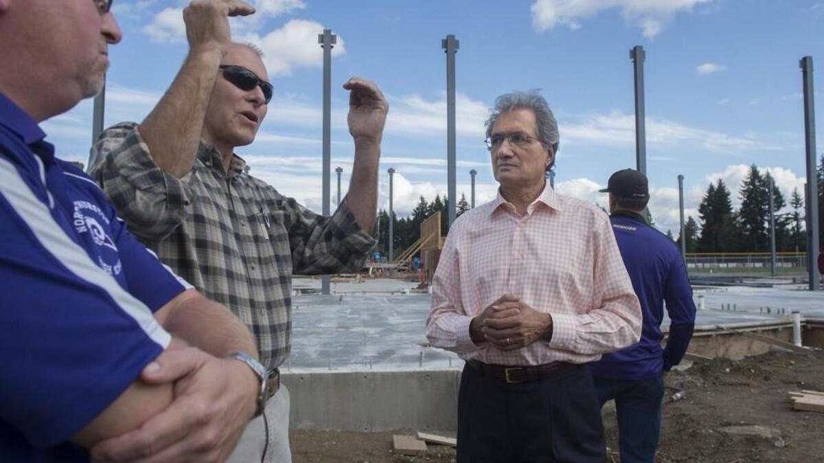 
North Thurston Principal Steve Rood, from left, Mike Laverty, district director of construction, and district Superintendent Raj Manhas tour the new gymnasium construction, part of a two-phase, $40 million construction and remodeling project at North Thurston High School on Friday. 
