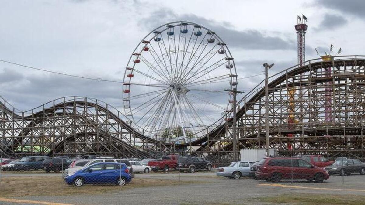 The new 108-foot Grand Wheel, located adjacent to the fair’s classic wooden roller coaster, looms over the midway at the Washington State Fairgrounds.