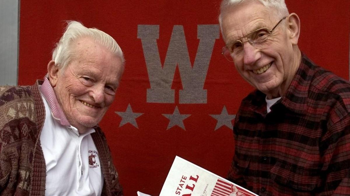 Rod Giske, left, and Earl Brenneis were teammates on the 1941 Washington State College football team that played a game with Texas A&M in Tacoma's Stadium Bowl on the eve of the Pearl Harbor attack. They posed for this picture on Dec. 2, 2004 at Giske’s home near Chehalis. Giske held his most-inspirational Bohler Medal and Brenneis held a media guide from their college football days. The Crimson and Gray blanket that forms a backdrop for this photo was awarded to Giske for earning three varsity letters and graduating from WSC. Brenneis died in 2013. He was 91. Giske died in 2014. He was 92.