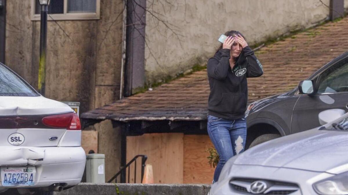 A woman walks away in anguish after visiting the scene of a fatal apartment fire at Spanish Hills apartments in Tacoma on Tuesday.