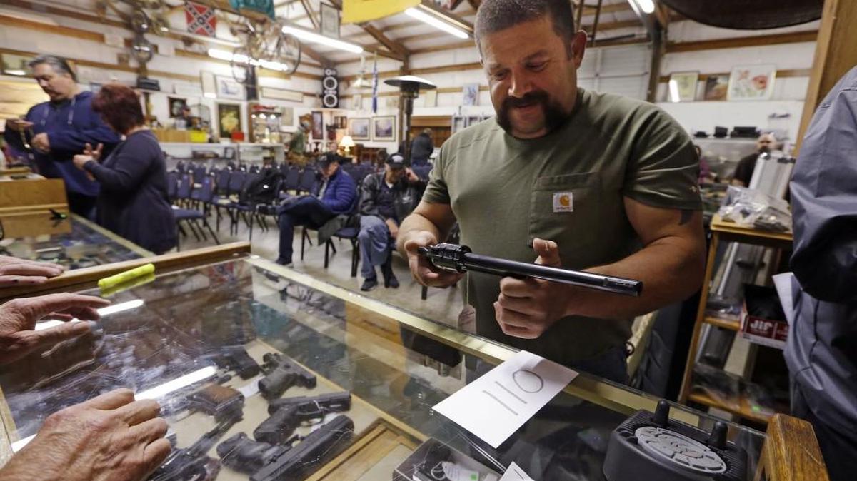 In this Oct. 20, 2017 photo, customer Jim Meadows looks over a Ruger Super Blackhawk .44-caliber magnum revolver at Johnny's Auction House in Rochester, Washington. The Washington state public-employee pension fund includes investments in Ruger and other gun manufacturers.