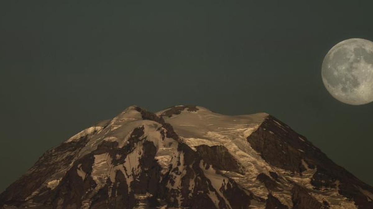 The moon rises over Mount Rainier seen from Longbranch on the eastern shore of the Key Peninsula Thursday.
