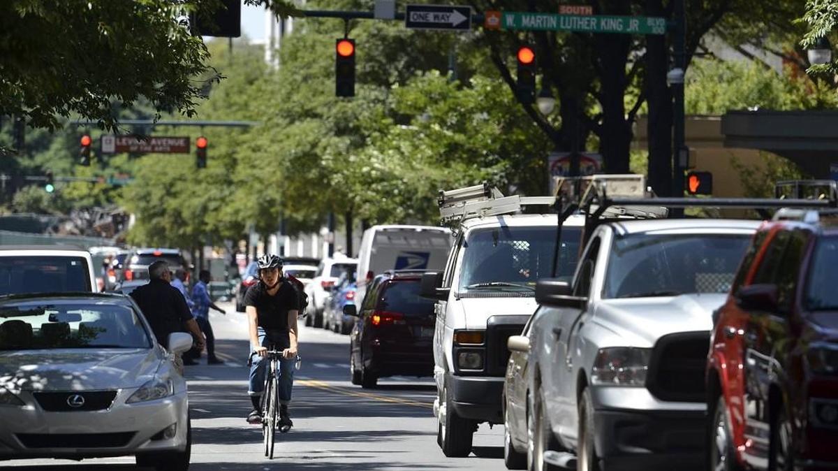 Technically, bicyclists should wait in line at a red light like any other vehicle. But is it that big a deal to let them move to the front, even if you have to pass them again?