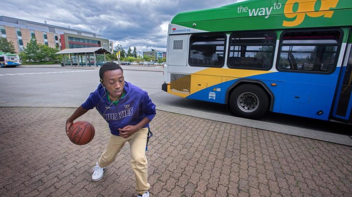 Antonyo Warren, 17, practices his basketball moves while waiting for a bus to go home to Fircrest at the Tacoma Community College Transit Center in Tacoma on Monday, July 11, 2016. Warren is planning to tryout for the basketball team next year.