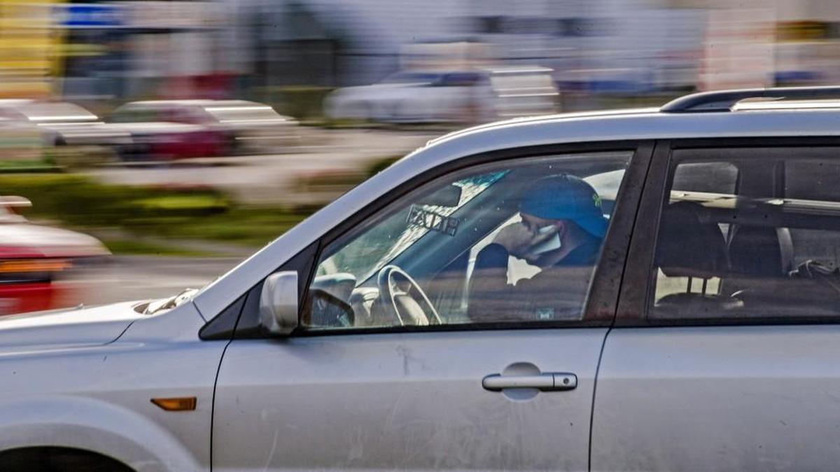 A motorist uses a cell phone on South 72nd Street in Tacoma on April 3, 2017. Talking on your phone while behind the wheel today will get you a ticket.