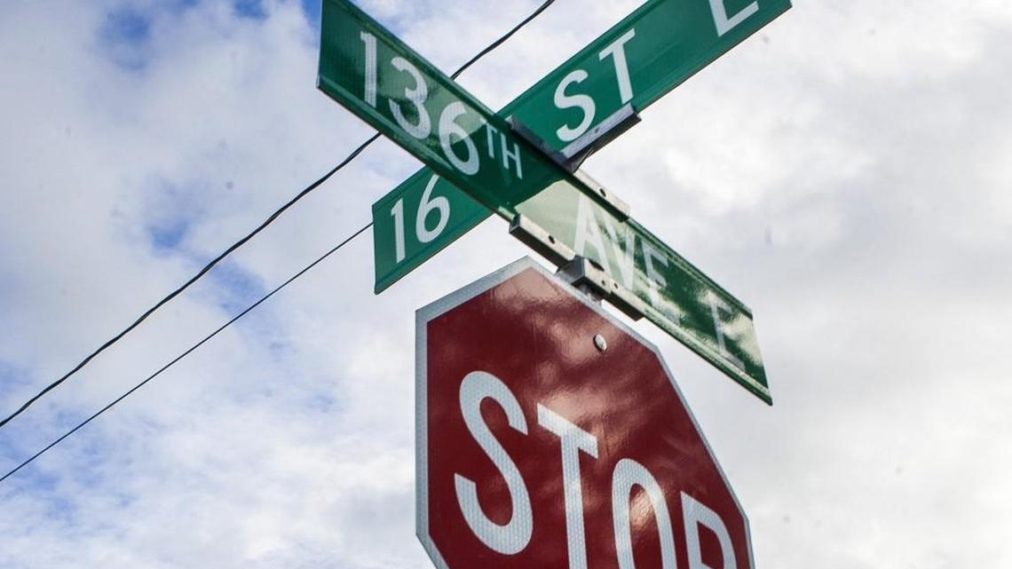 A stop sign and street signs are shown on the intersection of 136th Avenue East and 16th Street East in Sumner, Washington. Here’s what to know about rolling stops in California.