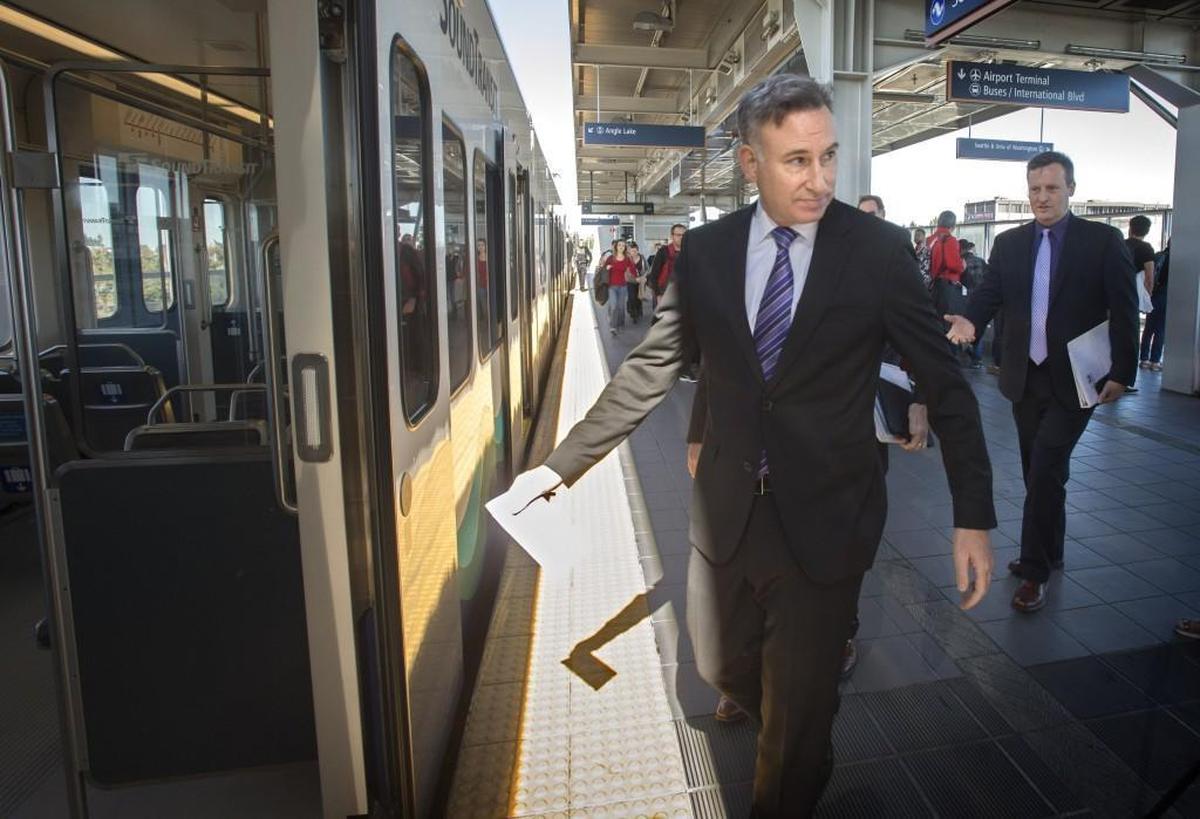 Dow Constantine, center, and Sound Transit board member Dave Upthegrove, right, board a Link train to Angle Lake Station in SeaTac in September 2016. Constantine is now a finalist for the CEO job at Sound Transit.