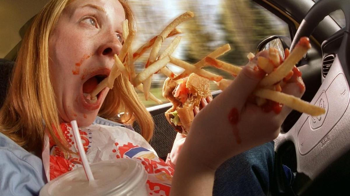“If you drive erratic because you drop a fry and try to pick it up or spill ketchup, et cetera, you can be ticketed for distracted driving,” said Tacoma Police spokeswoman Loretta Cool. Kirsten Gretza plays the role of a distracted driver in a file photo from 2000.