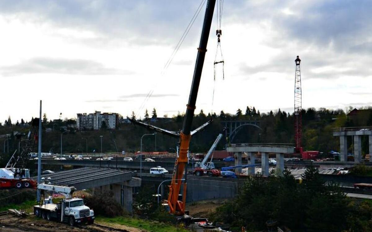 Crews using a 550-ton crane place the first girders, left, for the new Pacific Avenue overpass on Interstate 5 in Tacoma on Monday. The freeway will be shut down in both directions early Thursday and Friday while the remaining girders are placed.
