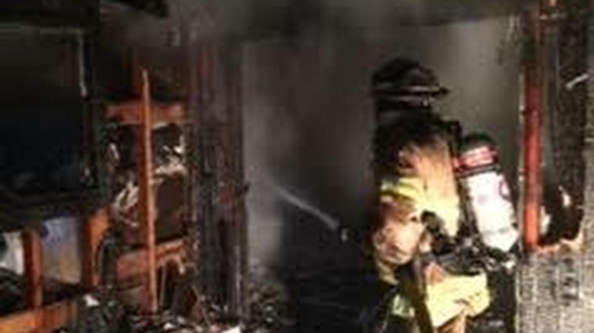 A firefighter puts out hot spots early Monday morning as an Auburn house fire comes under control.