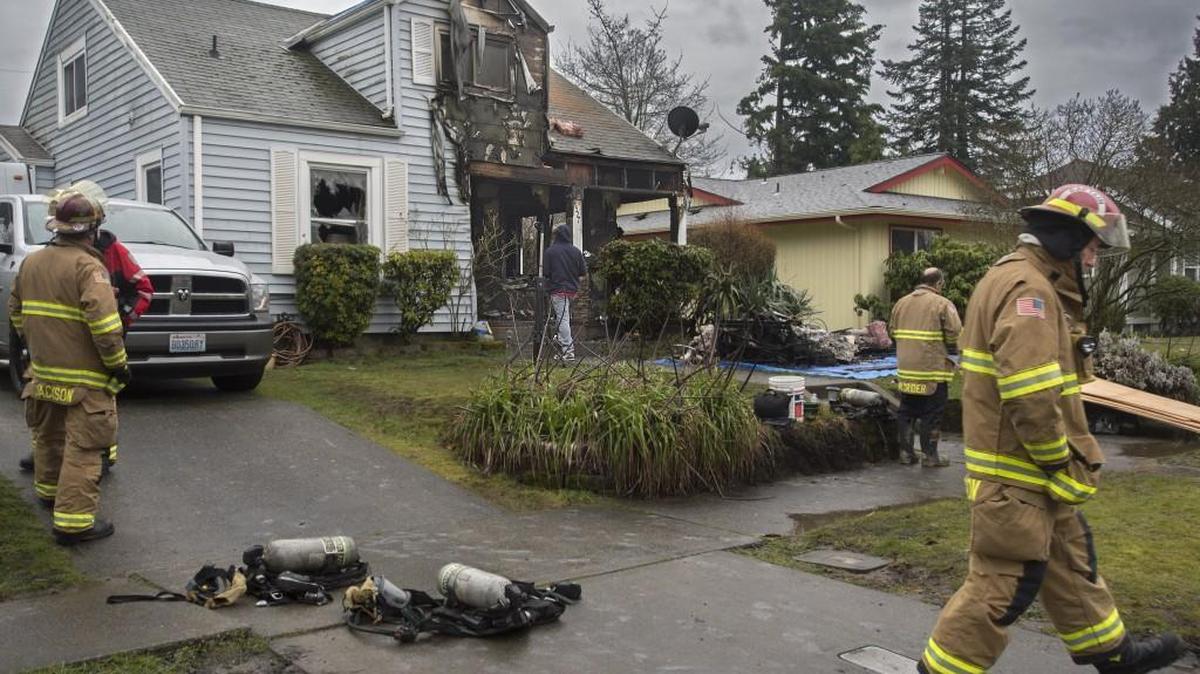 Tacoma firefighters work the scene of a fire at 4527 S. G St. in Tacoma early Wednesday.