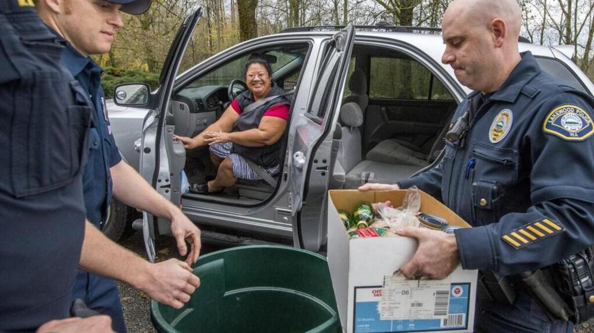 West Pierce firefighter Gus Hebish, left, and Ken Devaney of Lakewood police gather food donated by Angela Escalante of Tacoma near the headquarters of Lakewood police in 2014. It was part of the annual Fallen Officers Food Drive, which is happening again this year.