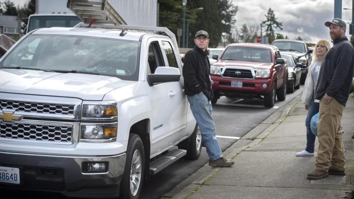 Contractor Arlen DeYoung, center, waits by his truck Monday for the Anderson Island ferry at the Steilacoom ferry dock.