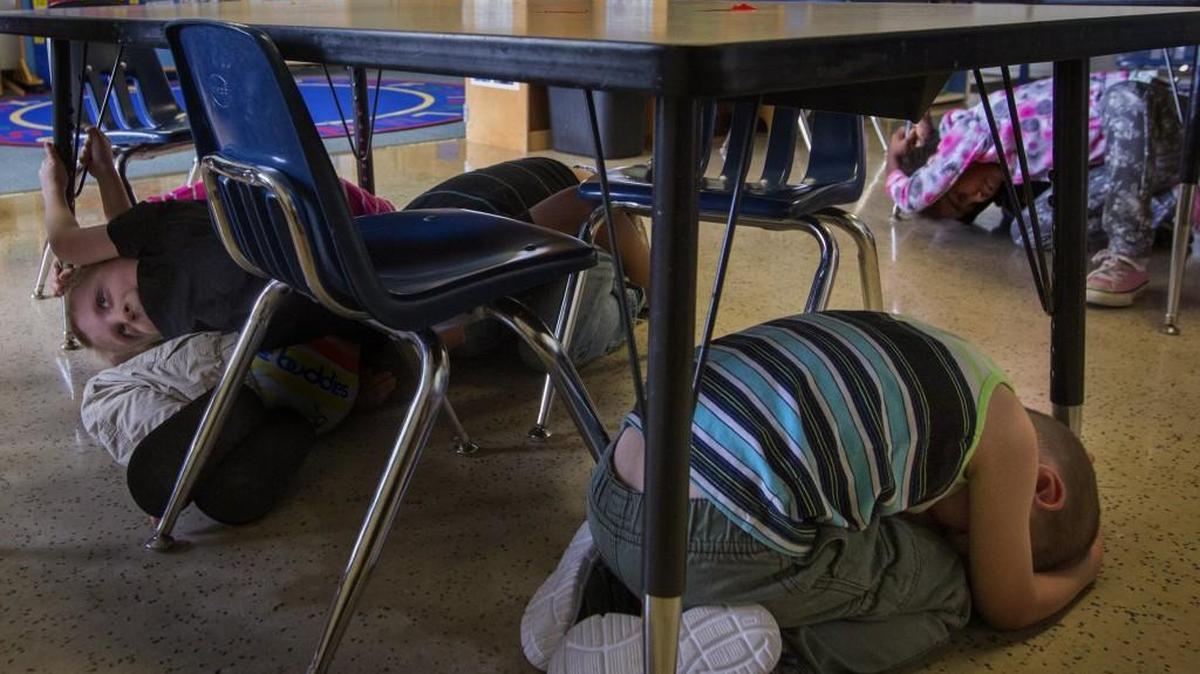 Preschoolers at Hopkins Preschool in Aberdeen crouch under tables during an earthquake drill. The plan is to get students under their desks until the shaking subsides and then to walk about three-quarters of a mile up a hill before the tsunami hits.