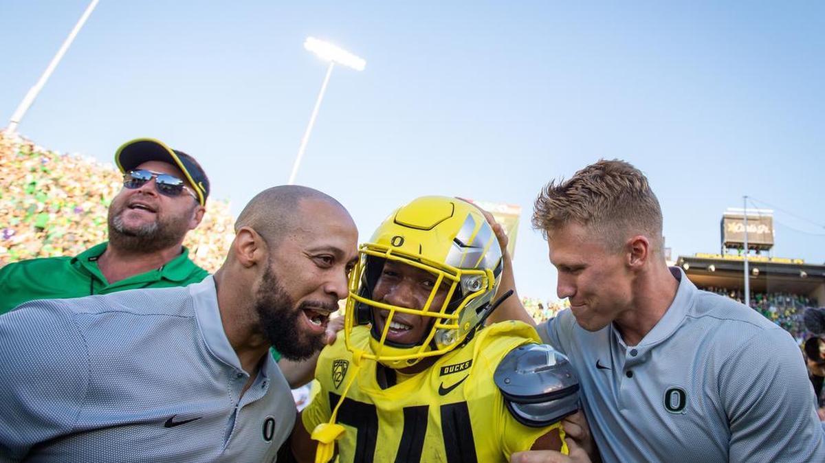 Oregon’s CJ Verde (34) is swarmed by coaches after his game-winning touchdown run. The University of Washington Huskies played the Oregon Ducks in a NCAA football game at Autzen Stadium in Eugene, Ore., on Saturday, Oct. 13, 2018.