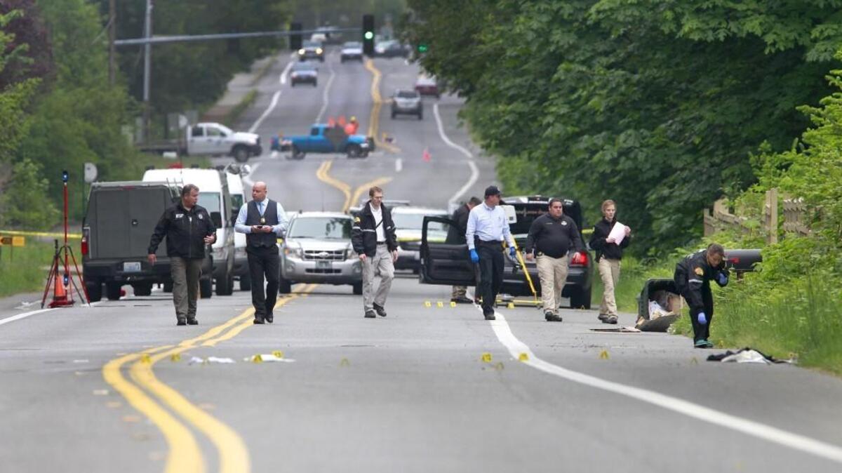 Investigators comb the scene of a officer-involved shooting on Cooper Point Road Thursday as two men suspected of attempting to steal beer from the west Olympia Safeway were shot by an Olympia police officer early Thursday morning.
