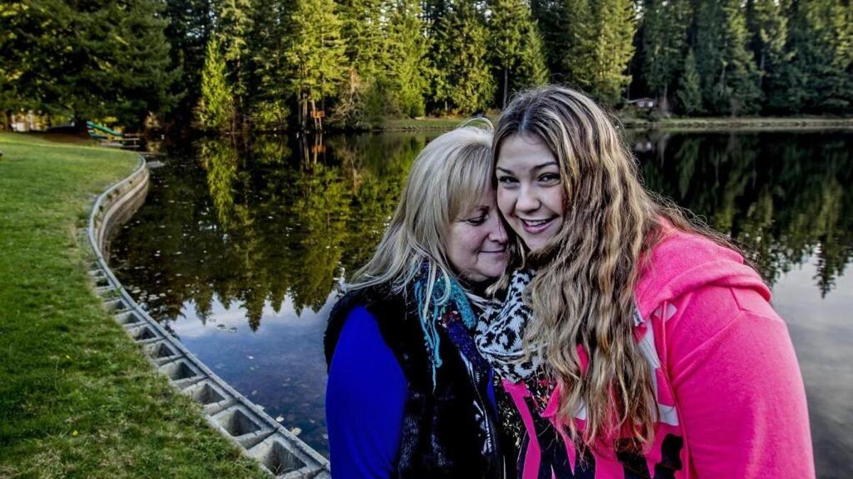Vanessa Haulund and her daughter Dayna Haulund, 21, on the shore of Sunset Lake where Dayna nearly drowned on Thanksgiving Day in 1995.