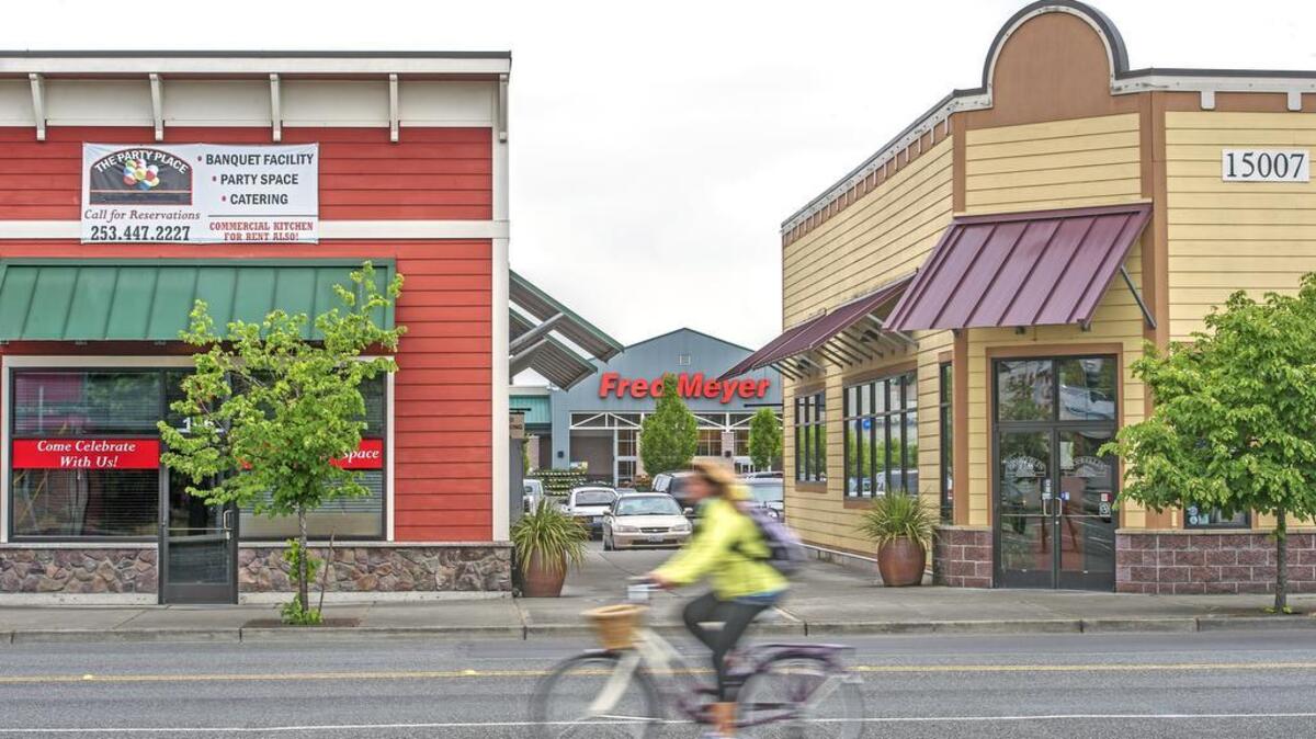 A bicyclist pedals by the development surrounding the Fred Meyer store and shops Friday in Sumner. The city’s proposed changes in design review guidelines are meant to keep small town’s Mayberry character without making it Disneyland.