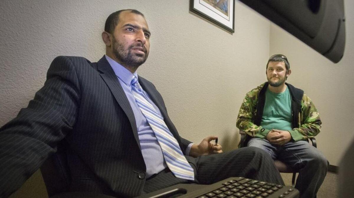 Dr. Asif Rashid Khan, left, talks with patient Daniel Hagerman at Northwest Integrated Health in Puyallup in November. Hagerman is getting treatment for heroin addiction.